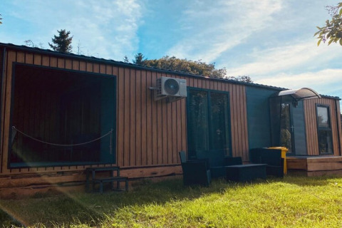 Holiday home Inselblick in Nowe Warpno, Germany, with wooden facade and outdoor seating on the lawn.
