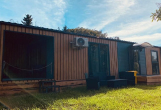 Holiday home Inselblick in Nowe Warpno, Germany, with wooden facade and outdoor seating on the lawn.