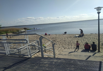Strandtafereel aan Holiday home Inselblick in Nowe Warpno, Duitsland, met mensen en strandpad.