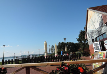 Vista dalla casa vacanze Inselblick a Nowe Warpno, Germania, con terrazza, lago e cielo azzurro.