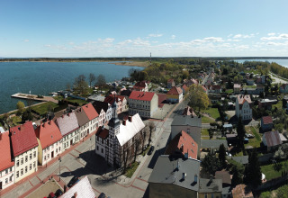 Aerial view of Holiday home «Inselblick in Nowe Warpno» by a waterfront with quaint houses in Germany.