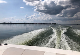 View from a boat on the lake near Holiday home Inselblick in Nowe Warpno, Germany, with clouds above.