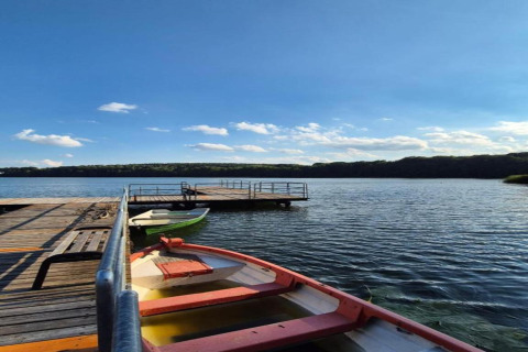 Udsigt over søen fra Holiday home «Maryna» i Tyskland med bådebro, både og blå himmel.