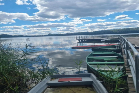 Både ved kaj nær siv med udsigt over søen og himmel, Holiday home «Maryna», Tyskland.