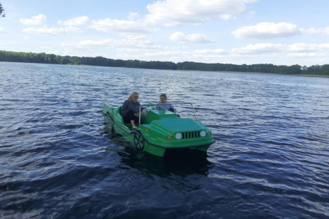 Deux personnes dans un pédalo vert en forme de voiture, sur un lac au Holiday home «Maryna» en Allemagne.