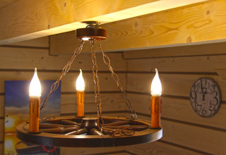 Lampadario rustico con lampadine a candela in una stanza di legno presso Holiday home 'Maryna' in Germania.