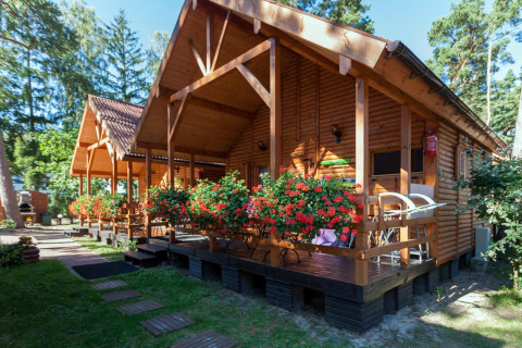 Bungalow in legno con fiori colorati a Domki letniskowe Pobierowo, immersi nel verde in Germania.