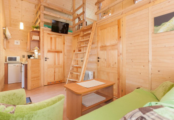 Interior view of Domki letniskowe Pobierowo, a cozy lodge with loft, sitting area, kitchenette, and wood decor.