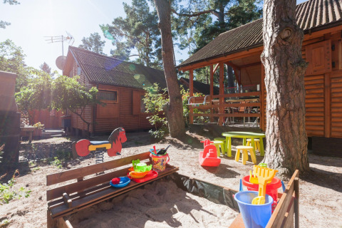 Parco giochi con sabbiera, giocattoli e casette in legno al sole presso Domki letniskowe Pobierowo in Germania.