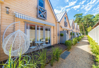 Houten vakantiehuisjes met terrassen en hangstoelen aan Holiday Cottage voor 5 personen in Pobierowo, Duitsland.