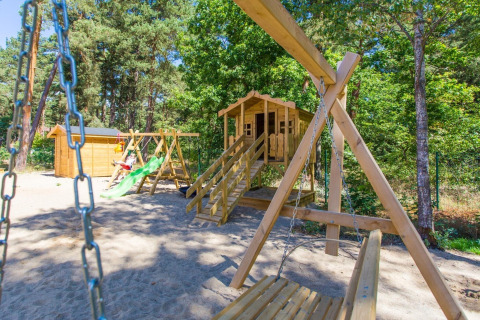 Speelplein met schommels, glijbaan en houten hut aan Holiday cottage for 5 people Pobierowo in Duitsland.