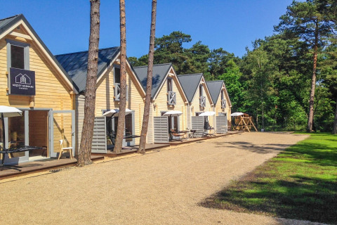 Vakantieverblijf voor 5 personen in Pobierowo, Duitsland, houten buitenkant en terras met parasols.