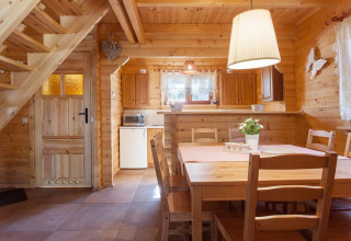 Gezellige houten vakantiewoning met eettafel, trap en keuken in Wooden holiday cottages Pobierowo.