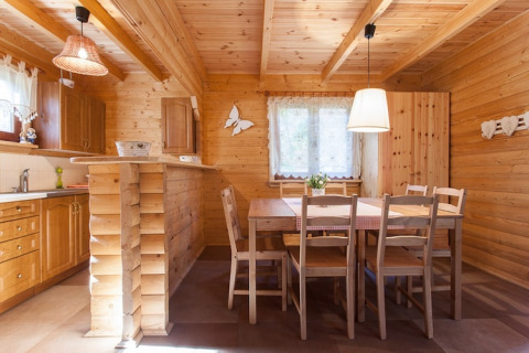 Gemütliche Holzhütte mit Küche und Essbereich bei Wooden holiday cottages Pobierowo in Deutschland.