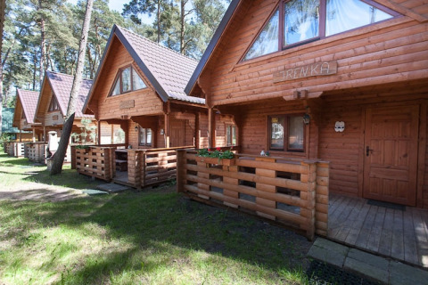 Holzferienhäuser bei Wooden holiday cottages Pobierowo, mit Terrassen und umgeben von Wald in Deutschland.