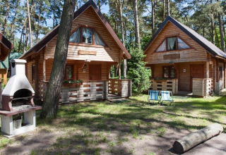 Houten vakantiechalets in een groene bostuin met barbecue bij Wooden holiday cottages Pobierowo, Duitsland.