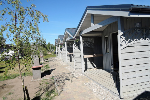 Outdoor photo of Aquarius Cottages for 2 people in Germany, showing several small gray cabins in sunshine