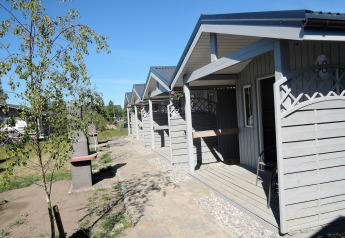 Outdoor photo of Aquarius Cottages for 2 people in Germany, showing several small gray cabins in sunshine