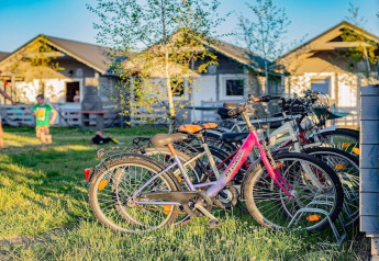 Bicicletas aparcadas frente a Aquarius Cottages para 2 personas, niños jugando, cabañas en Alemania.