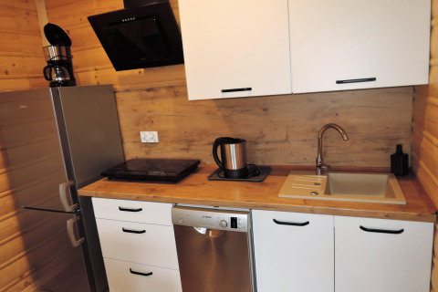 Moderne kitchenette in Lazurowy Zakątek-lodge in Duitsland met koelkast, vaatwasser en spoelbak.