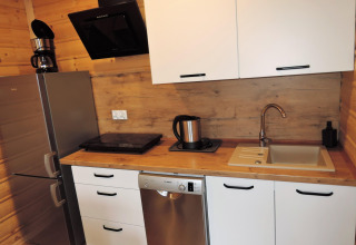 Cocina moderna en la cabaña Lazurowy Zakątek en Alemania con nevera, fregadero y lavavajillas.