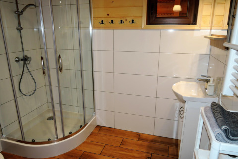 Moderne badkamer in Lazurowy Zakątek, Duitsland, met douchecabine, wastafel en een houten vloer.