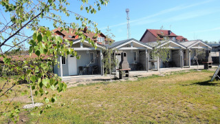Außenansicht der Aquarius Cottages mit kleinen Terrassen, Sitzgelegenheiten und Grill, für 5 Personen.