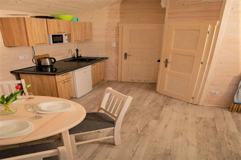 Kleine keuken in de Aquarius Cottages voor 5 personen in Duitsland, met houten wanden en eettafel.