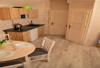 Kleine keuken in de Aquarius Cottages voor 5 personen in Duitsland, met houten wanden en eettafel.