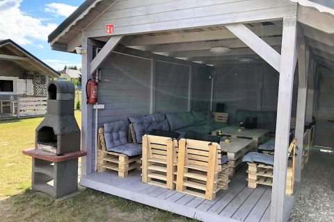 Overdekte zithoek met palletmeubels en barbecue bij Aquarius Cottages - voor 5 personen in Duitsland.