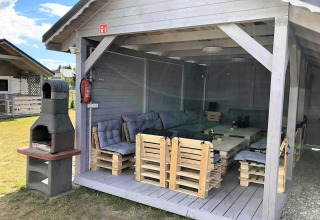 Overdekte zithoek met palletmeubels en barbecue bij Aquarius Cottages - voor 5 personen in Duitsland.