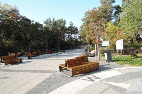 Buitenruimte bij Aquarius Cottages in Duitsland met banken, bomen en een rustige sfeer.