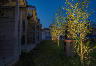 Avondfoto van verlichte bomen en huisjes bij Aquarius Cottages in Duitsland, gezellige sfeer buiten.