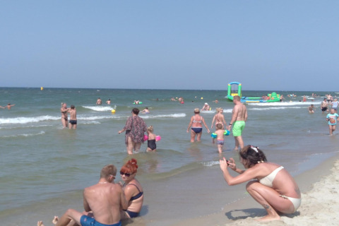 Families and children relax and play at a busy beach near Aquarius Cottages for 5 people in Germany.