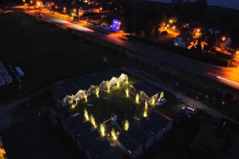 Luchtfoto bij nacht van Aquarius Cottages in Duitsland met verlichte huisjes en paden.