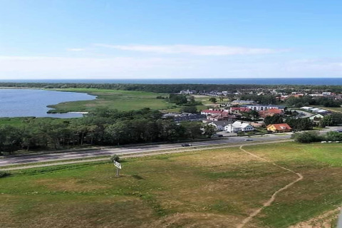 Uitzicht op meer, groene weiden en kustplaats vanaf Aquarius Cottages in Duitsland op een zonnige dag.