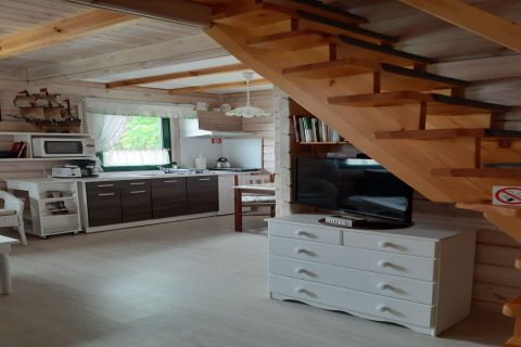 Interieur van een charmant huisje met houten trap, moderne keuken en sfeervolle inrichting.