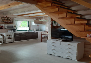 Interieur van een charmant huisje met houten trap, moderne keuken en sfeervolle inrichting.