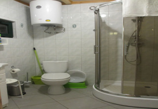 Moderne badkamer met glazen douche, toilet en boiler in een charmant huisje op een heuvel in Duitsland.