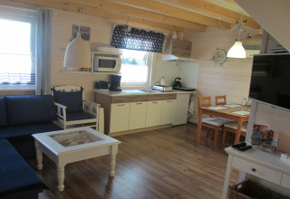 Woon- en keukenruimte in de 'House on a Hill'-lodge in Duitsland met houten interieur en gezellige sfeer.
