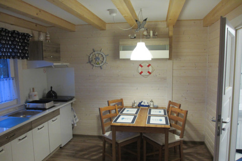 Lichte keuken en eetruimte in lodge 'House on a hill' in Duitsland met nautische decoratie en houten wanden.