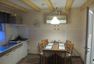 Lichte keuken en eetruimte in lodge 'House on a hill' in Duitsland met nautische decoratie en houten wanden.