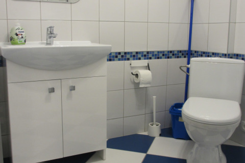 Moderne badkamer met witte wastafel, toilet en blauwe mozaïektegels in House on a Hill, Duitsland.