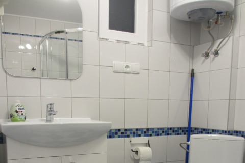 Moderne badkamer in House on a hill lodge, Duitsland, met wastafel, spiegel, toilet en blauwe dweil.