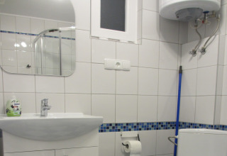 Moderne badkamer in House on a hill lodge, Duitsland, met wastafel, spiegel, toilet en blauwe dweil.