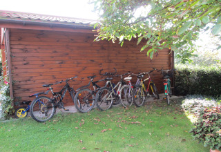 Vijf fietsen staan geparkeerd bij een houten tuinhuis onder een boom bij House on a Hill, Duitsland.