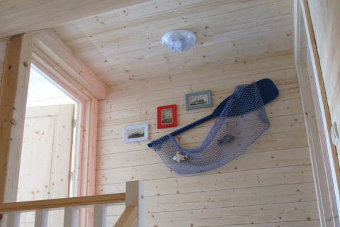 Houten gang in House on a hill lodge, Duitsland, met nautische decoratie en ingelijste foto's.