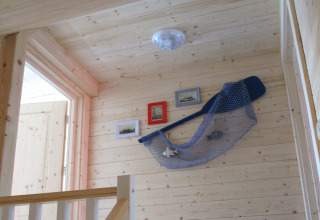 Houten gang in House on a hill lodge, Duitsland, met nautische decoratie en ingelijste foto's.