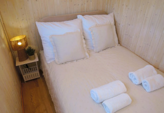 Acogedor dormitorio en Turkusowa osada Wapnica con cama doble, toallas limpias y lámpara de noche.