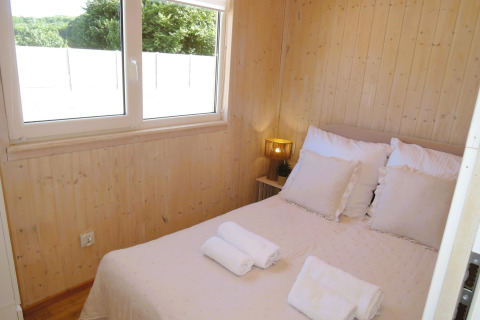 Lichte houten slaapkamer met tweepersoonsbed en uitzicht op de natuur in Turkusowa osada Wapnica.